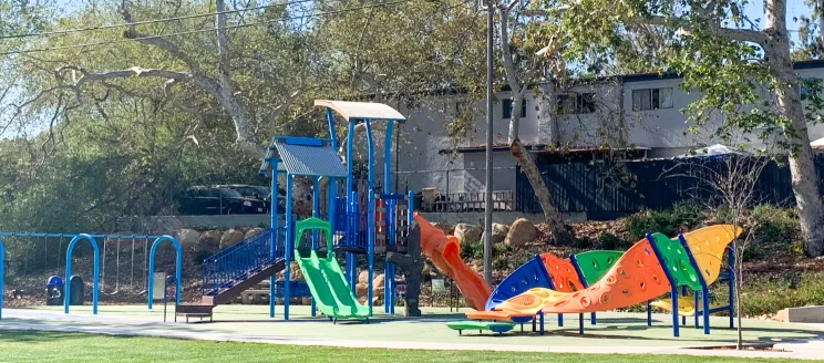 A colorful kids play structure at the park