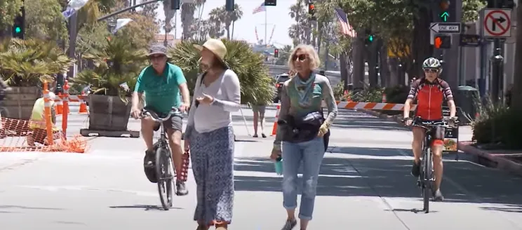 A group of people walking along State Street and riding bikes