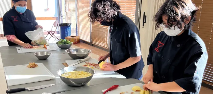 three students preparing food