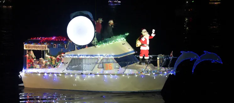 Santa on a boat decorated with Christmas lights