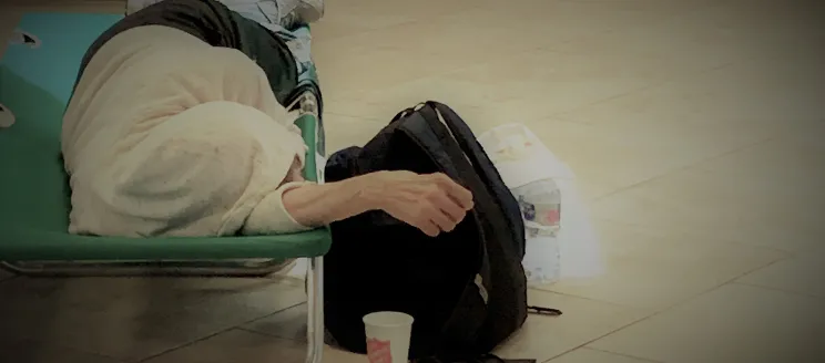 Photo of homeless person lying down with backpack