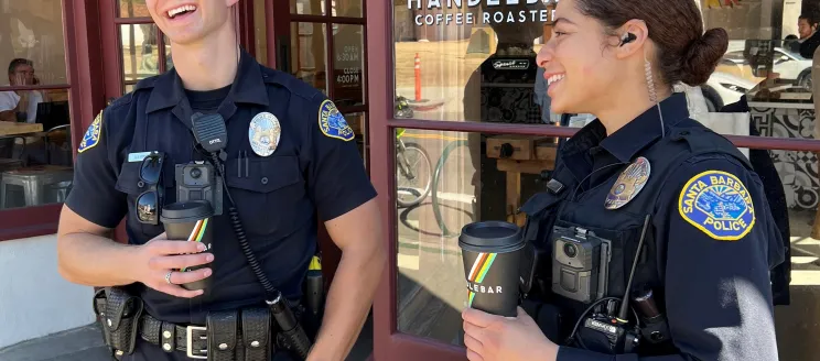 Two police officers holding coffee cups