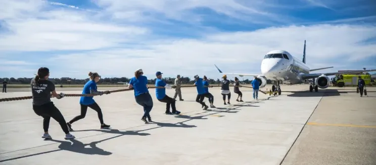 People pulling an airplane