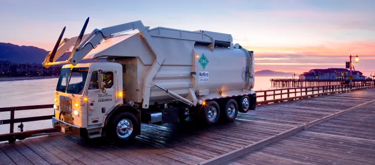 MarBorg trash truck driving down stearn's wharf with a sunset behind it