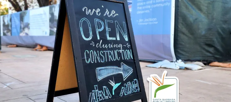 Graphic depicts a chalkboard sign on a sidewalk that reads "we're open during construction"