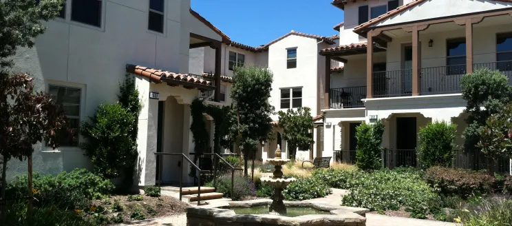 Image shows a housing development in Santa Barbara. The houses are white with surrounding greenery