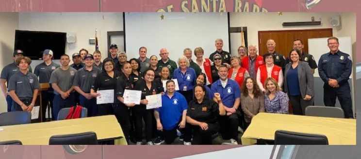 Image shows a large group of people smiling, men and women from all walks of life celebrating their achievement with City staff