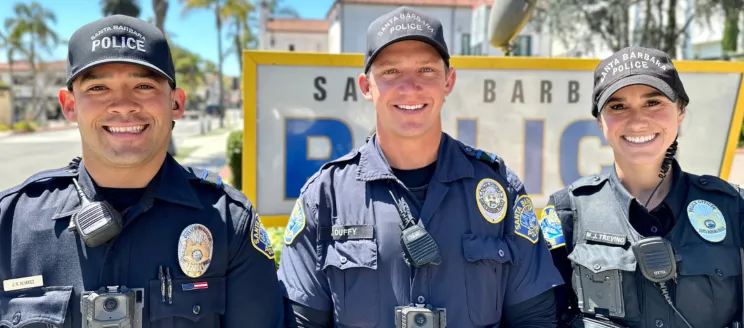 Image shows three officers, two men and a woman, smiling in uniform.