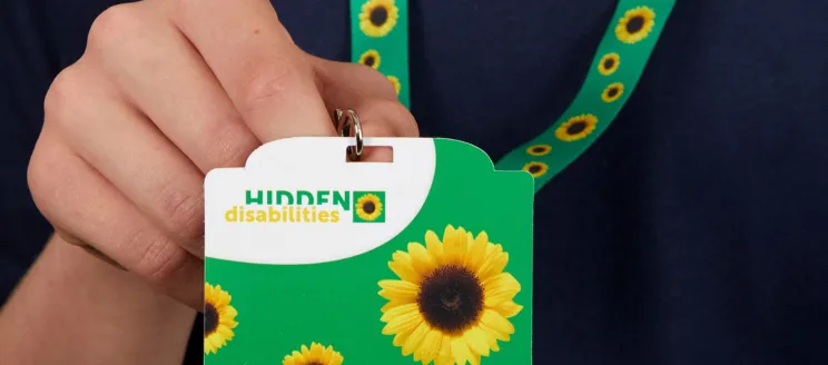 Image shows a green lanyard with sunflowers and a badge that reads "hidden disabilities"