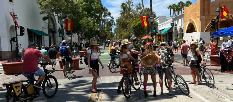 Image shows a large group of pedestrians on State Street walking and on bikes