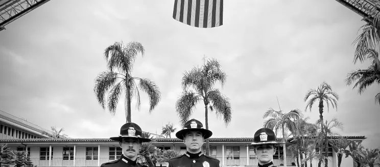 Three Officers Standing in front of the American Flag
