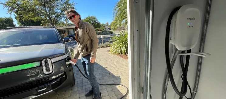 Man charging his electric vehicle in driveway