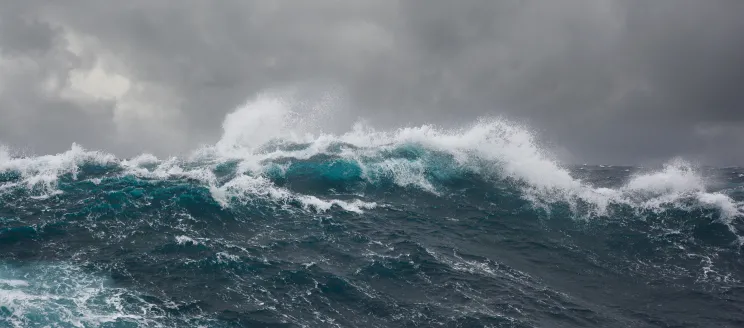 Large storm waves, deep blue with a gray sky