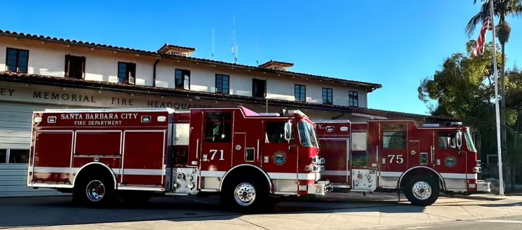 Two brand new shiny red fire engines in front of Fire Department Station 1  on carrillo street