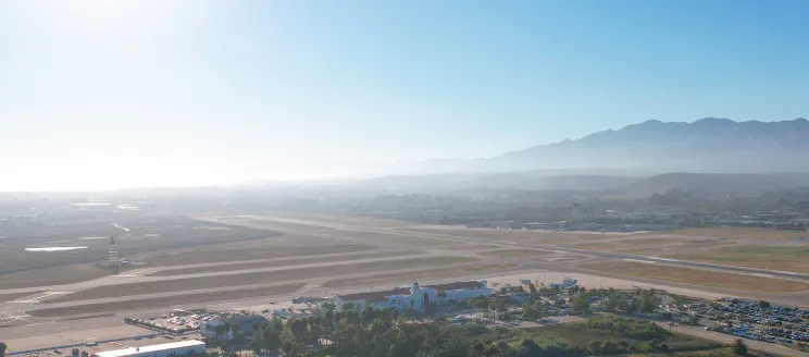 Aerial shot of Santa Barbara Airport, with the Terminal in the foreground and mountains in the background