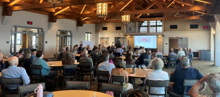 Community meeting with residents viewing a powerpoint presentation in the main room of the Cabrillo Pavilion