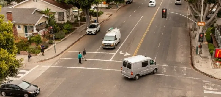 Milpas Intersection, pedestrians in crosswalk as vehicles share the intersection.