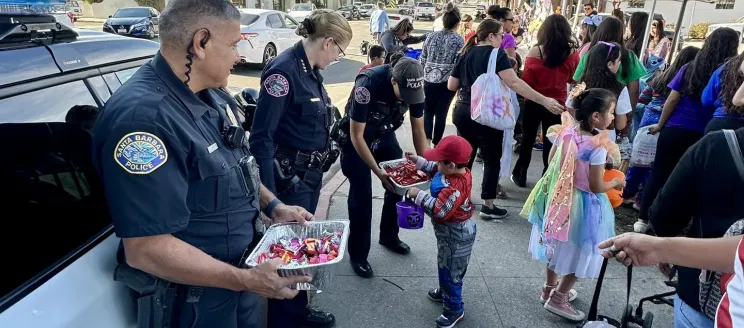 Chief Gordon and Officer Adrian Gutierrez  handing out candy at a community event.jpg