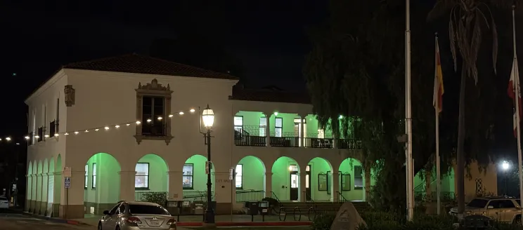 City Hall illuminated by green lights.