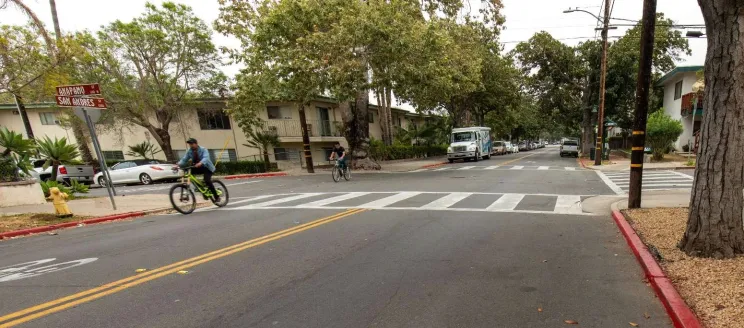 Intersection of Anapamu and San Andres Streets, cyclist sharing the road with vehicles.