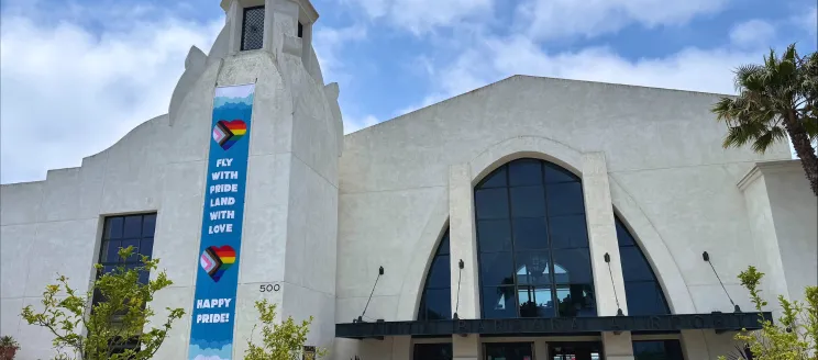 SBA terminal with “Fly with Pride, Land with Love” banner.