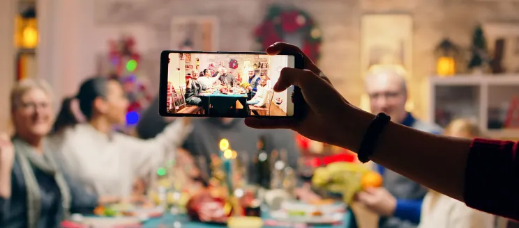 A photo being taken of a family holiday dinner with a mobile phone
