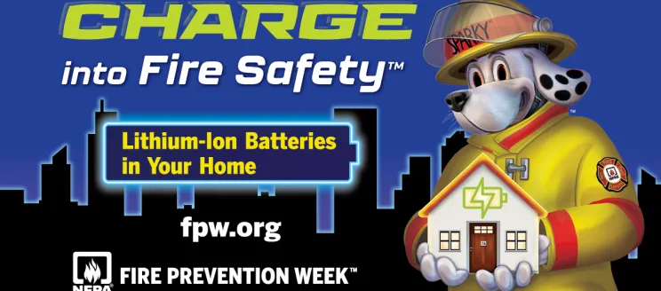 Sparky the Fire Dog, wearing yellow firefighter gear, holds a model of a home in his hands with a city skyline in the background. The image promotes Fire Prevention Week 2025 with the theme “Charge into Fire Safety,” highlighting lithium-ion battery safety at home.