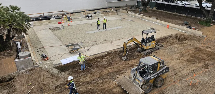photo of construction projects downtown shows workers reviewing a site and machinery on the sides