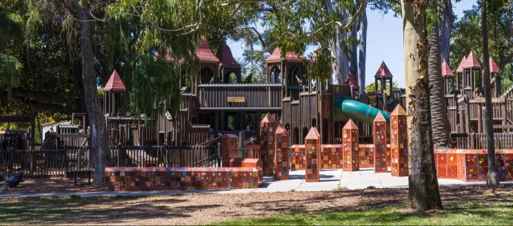 Kid’s World Playground surrounding trees.