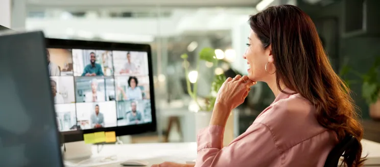 woman watching an online meeting at her desk