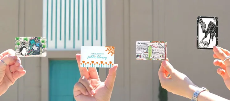 Library Cards being held up in front of the Central Library
