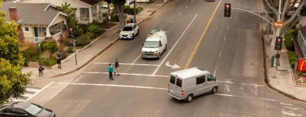 Milpas Intersection, pedestrians in crosswalk as vehicles share the intersection.