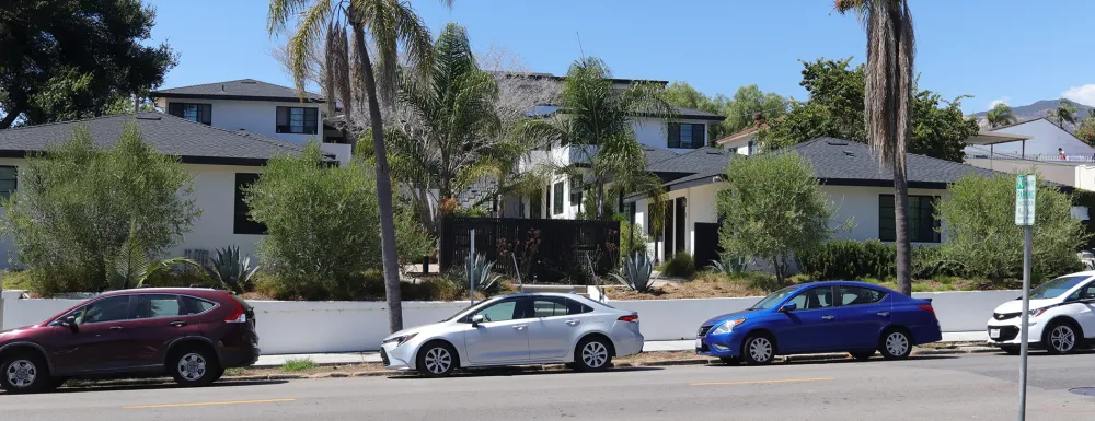 Picture of cars parked along street in front of multi unit housing