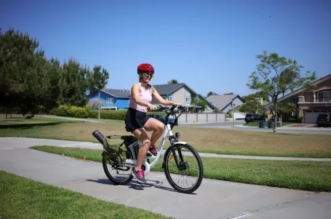 Woman in a helmet riding a bicycle along a path.