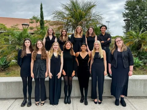 Dos Pueblos Jazz Choir posing as a group in front of some greenery