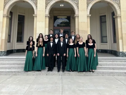 Santa Barbara High School Choir posing in front of a large building