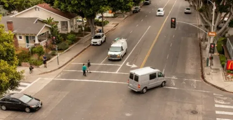 Milpas Intersection, pedestrians in crosswalk as vehicles share the intersection.
