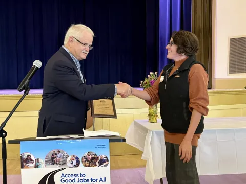 Preschool Administrator Erika Ronchietto and Mayor Rowse shaking hands.