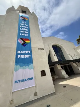“Fly with Pride, Land with Love” banner flysba.